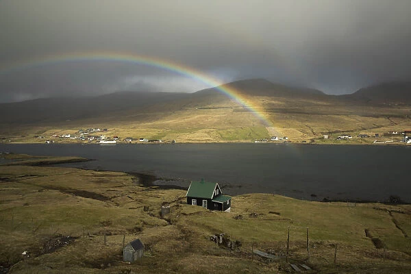A rainbow above a solitary house in Nesvik. Streymoy, Faroe Islands