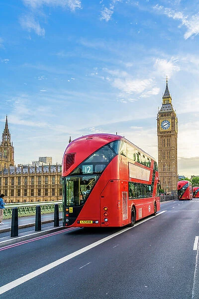 A red London bus on Westminster Bridge, by Big Ben and Houses of Parliament (UNESCO World Heritage Site), London, England, Uk