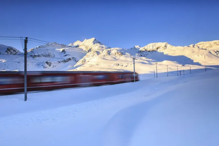 Framed Print : The red train of Bernina whizzes through the snow at the Bernina pass at dawn. Engadine Framed Print : The red train of Bernina whizzes through the snow at the Bernina pass at dawn. Engadine