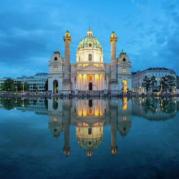 Reflection of illuminated Karlskirche at Karlsplatz at twilight, Innere Stadt, Vienna, Austria