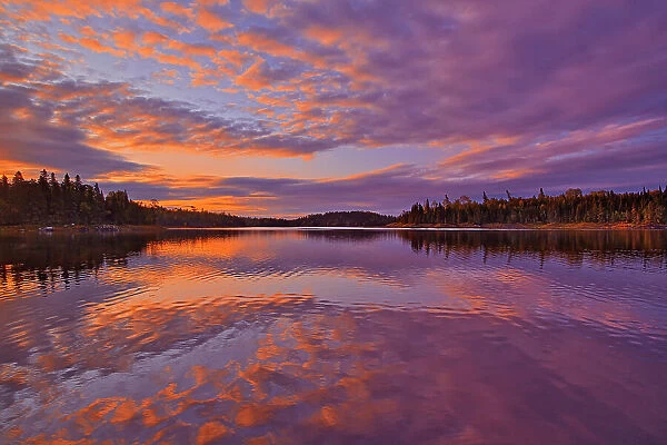 Reflection in Middle Lake at sunrise Kenora, Ontario, Canada