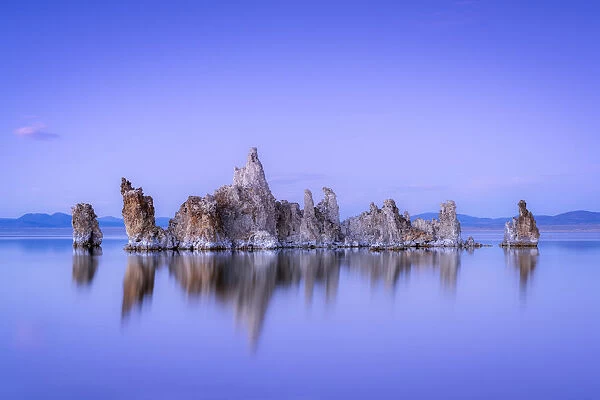 Reflection of rock formation in South Tufa on Mono Lake against blue sky at dusk