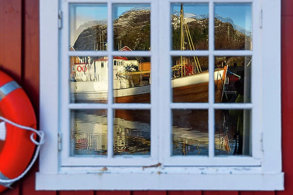 Reflections in a window of a Rorbu in Nusfjord, Flakstad, Flakstadoya, Nordland, Lofoten Islands, Norway