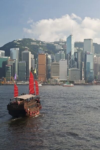 One of the last remaining Chinese sailing junks on Victoria Harbour, Hong Kong, China, Asia, viewed from Kowloon, Central skyine beyond