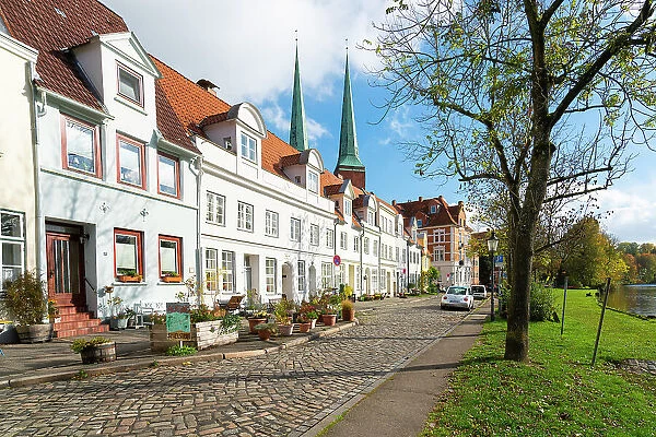 Residential buildings by Trave river with towers of Lubeck Cathedral in background, Lubeck, UNESCO, Schleswig-Holstein, Germany