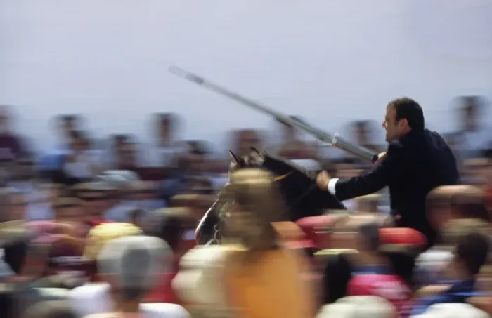 Framed Print : A rider on horseback speeds through the crowd attempting Framed Print : A rider on horseback speeds through the crowd attempting