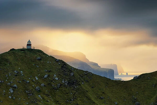 Risin og Kellingin during an autumn sunset, with the Kallur lighthouse in foreground, Eysturoy, Faroe Islands, Denmark