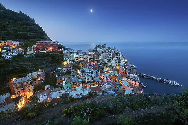 Rising moon over the small fishermen's town of Manarola, part of Cinque Terre in Liguria, in spring. Cinque Terre, Italy