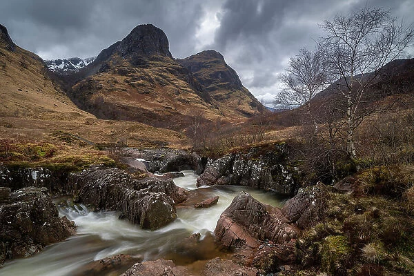 River Coe rushing through Glencoe valley beneath the Three Sisters mountains, Highlands, Scotland, UK. Spring (March) 2023