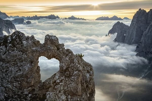A rocks heart, on a clouds sea, between rock walls. (Dolomites, Italy)