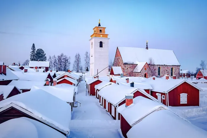 Framed Print : Roofs of cottages and bell tower covered with snow in the picturesque village of Gammelstad Church Town at dusk, Lulea, Sweden