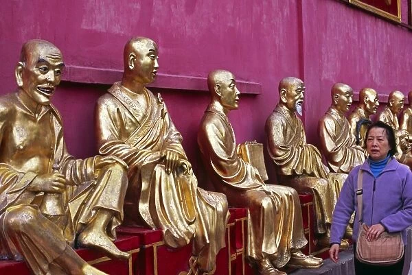 A row of golden Buddha statues greets visitors to the