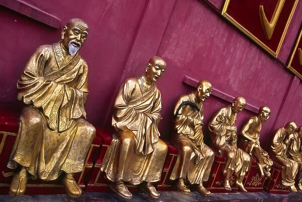 A row of golden Buddha statues at the Ten Thousand