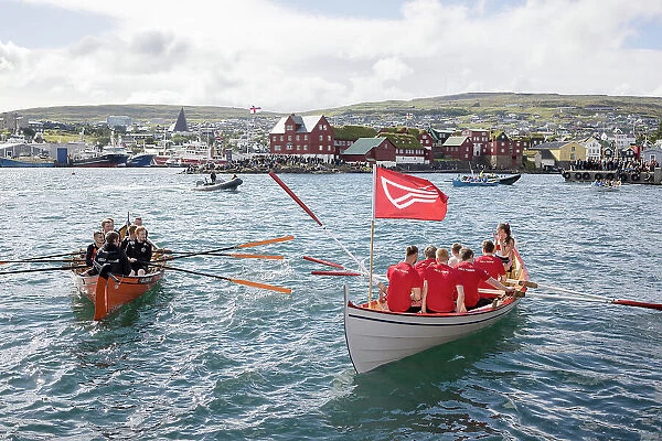Rowing boats after a competion in occasion of 'lavsoka festival in the city of Torshavn. In the background the red buildings of Tinganes. Island of Streymoy. Faroe Islands