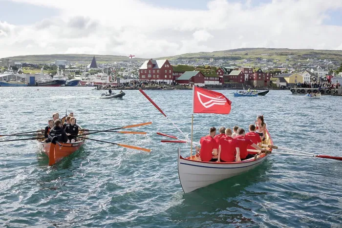 Framed Print : Rowing boats after a competion in occasion of lavsoka festival in the city of Torshavn. In the background the red buildings of Tinganes. Island of Streymoy. Faroe Islands