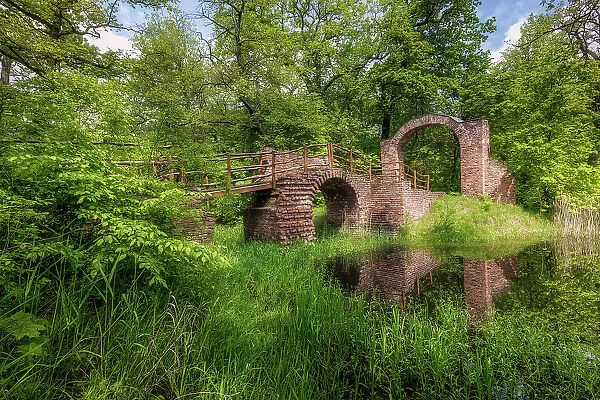 Ruins bridge in the Georgen garden - English style landscape park, NESCO World Heritage site of Dessau-Worlitz Garden Realm, Dessau, Saxony-Anhalt, Germany, Europe