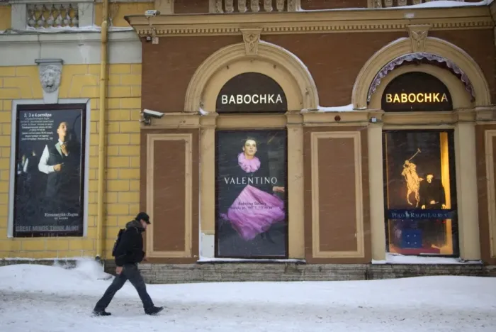 Framed Print : Russia, St. Petersburg; A man walking in front of high end clothes adverts in the city centre in Winter Framed Print : Russia, St. Petersburg; A man walking in front of high end clothes adverts in the city centre in Winter
