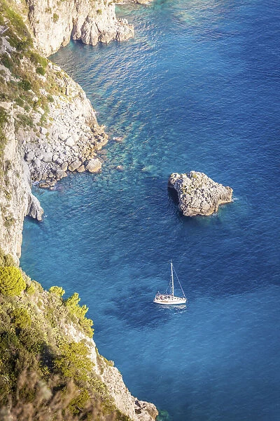 Sailboat in blue bay at the Faraglione rocks on Capri, Capri Island, Gulf of Naples