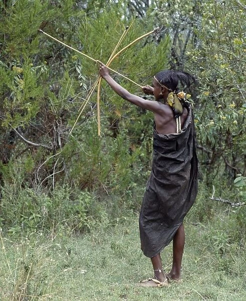 A Samburu initiate takes aim at a bird with a blunt arrow
