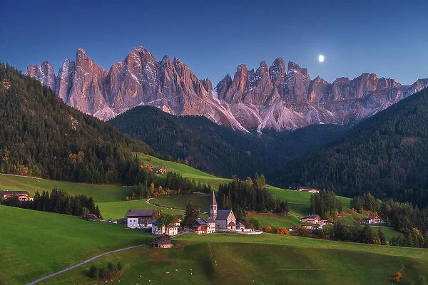 Santa Magdalena church, with the Odle rising tall in the background. Dolomites, Italy