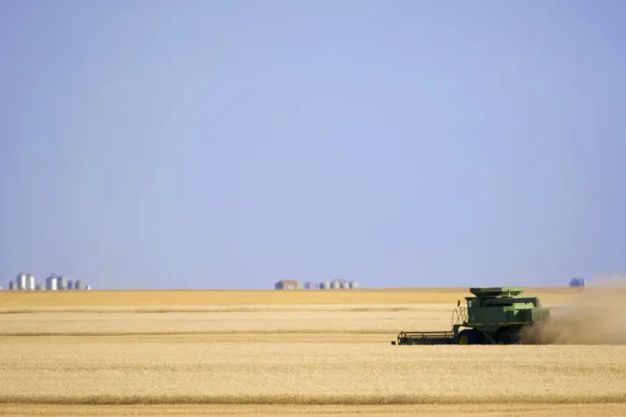 Framed Print : Saskatchewan; Canada. A combine harvesting wheat on the canadian prairie