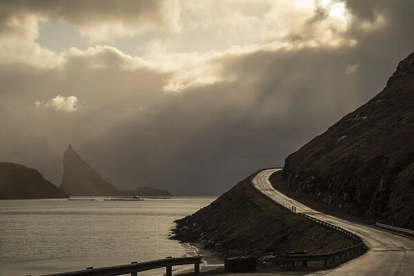 Scenic road in the island of Vagar. In the background the islet of Tindholmur. Faroe Islands