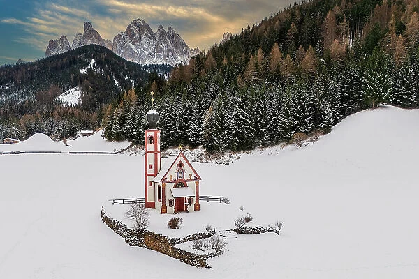 Scenic winter view of Church of St. Johann in Ranui with Odle (Geislergruppe) mountain group behind, Dolomites, Villnoss-Funes, South Tyrol, Italy
