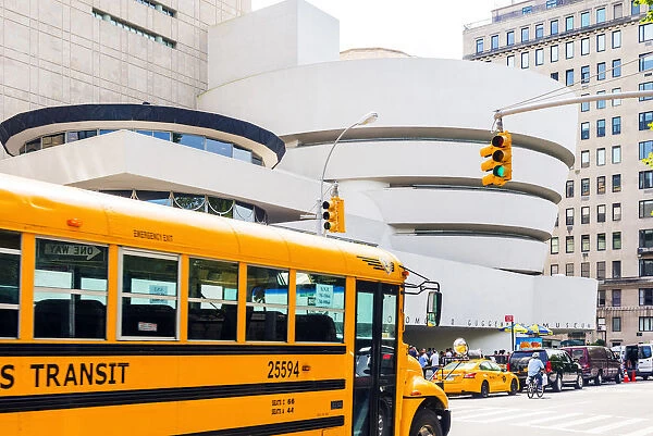 School bus passing the Solomon R Guggenheim museum, Manhattan, New York, USA