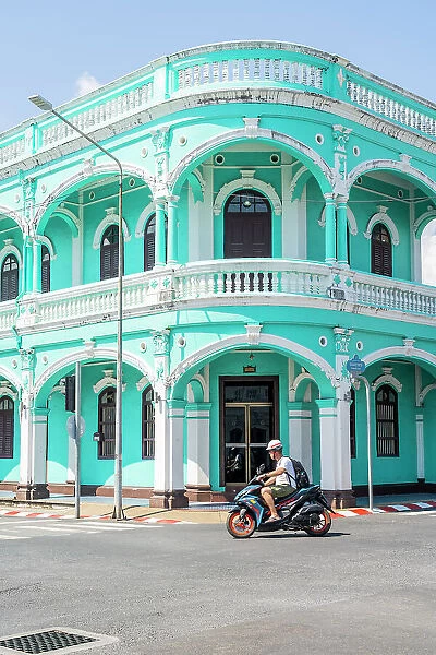 Scooter riding past beautiful buildings in the Old town, Phuket, Thailand