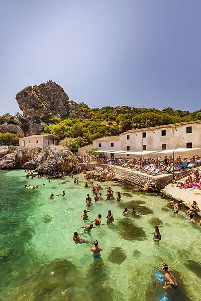 Scopello, Sicily. People taking a bath and sunbathing near the old tonnara