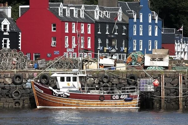 Scotland, Isle of Mull. Fishing boat and colourful waterfront houses at Tobermory harbour