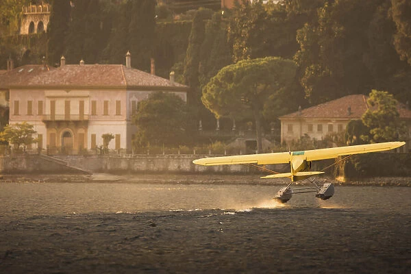A seaplane taking off in Como Lake at sunset. Lombardy, Italy