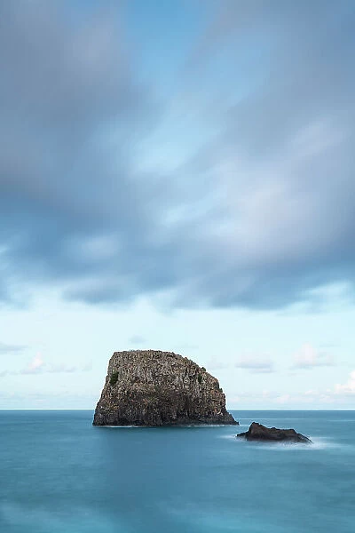 Seascape with rock in ocean by coast of Porto da Cruz at dusk, Machico District, Madeira, Portugal