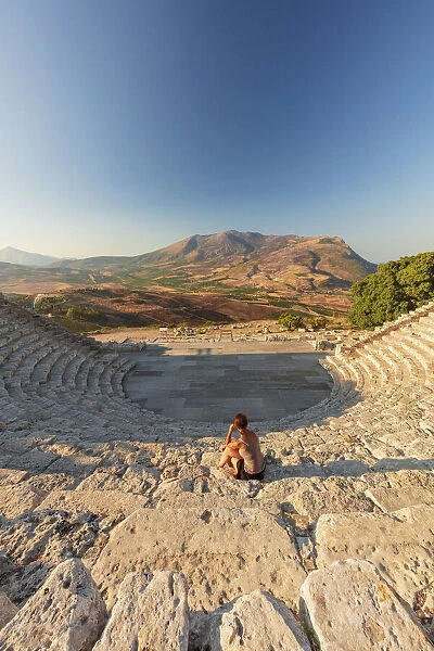 Segesta, Sicily. A woman sitting alone in the greek theater of Segesta at sunset