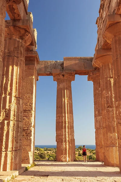 Selinunte, Sicily. A woman visiting an old Greek temple at with the sea in the