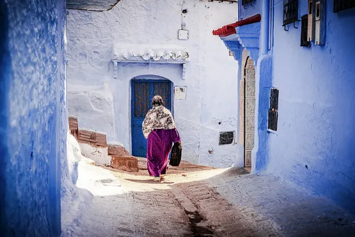Framed Print : Senior woman with hijab walking among blue buildings of medina, Chefchaouen, Morocco Framed Print : Senior woman with hijab walking among blue buildings of medina, Chefchaouen, Morocco