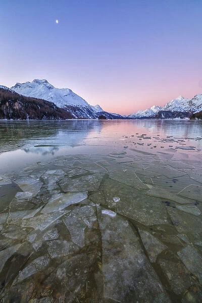 Sheets of ice on the surface of Lake Sils in a cold winter morning at dawn Upper Engadine