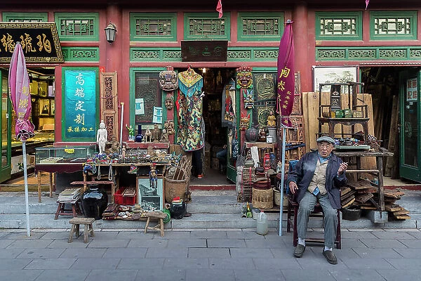 Shopkeeper outside antique shop, Beijing, China