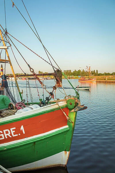 Shrimp boats in the harbor of Greetsiel at sunset, East Frisia, Lower Saxony, Germany