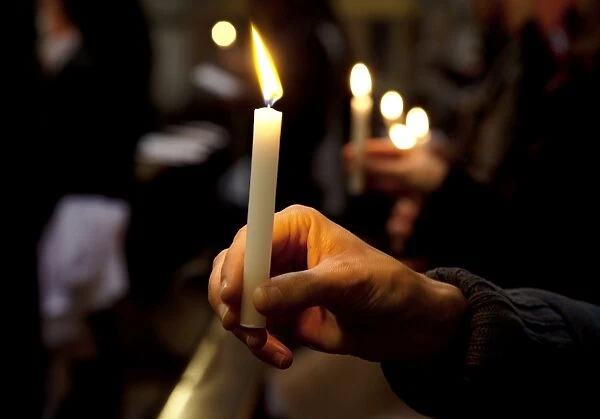 Sicily, Italy, Western Europe; A believer, holding a candle during the Easter Eve ceremony at the Trapani