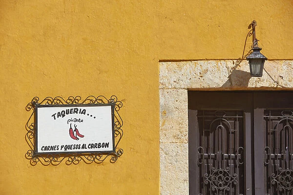 The signboard of a traditional 'Taqueria'restaurant in a street of Izamal, Yucatan, Mexico. Izamal is known in Yucatan as the 'Yellow City', as most of its buildings are painted yellow