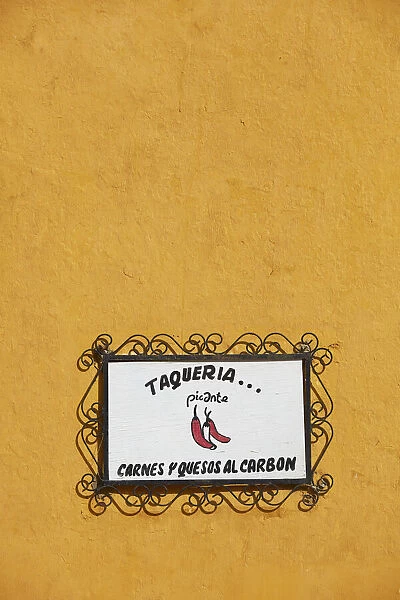 The signboard of a traditional 'Taqueria'restaurant in a street of Izamal, Yucatan, Mexico. Izamal is known in Yucatan as the 'Yellow City', as most of its buildings are painted yellow