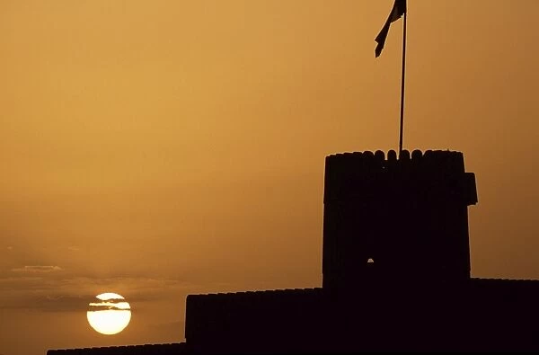 Silhouette of one of the towers of Ras al Hadd Castle at sunset