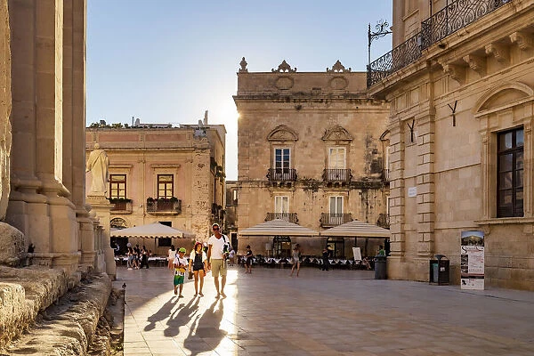 Siracusa, Sicily. People walking on Duomo square near the Cathedral at sunset