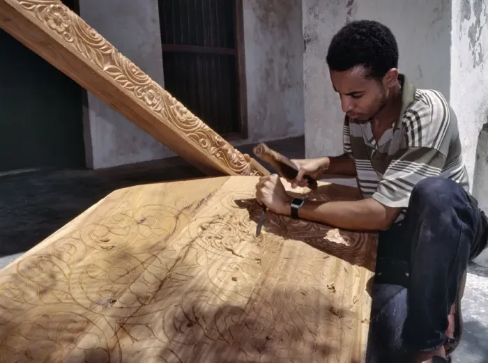 Framed Print : A skilled craftsman with traditional tools carves a Framed Print : A skilled craftsman with traditional tools carves a