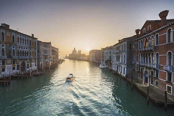A small boat sails along Canal Grande view from the Academy bridge, Venice, Veneto, Italy