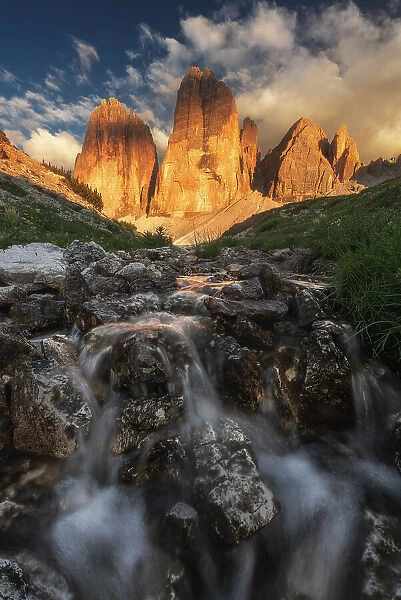 A small stream comes down from the Tre Cime di Lavaredo during a summer sunset. Dolomites, Italy