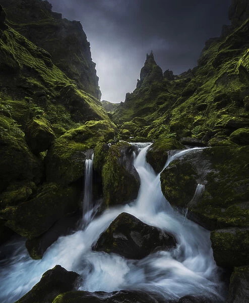 A small stream running through a lush green canyon in summer, Southern Iceland