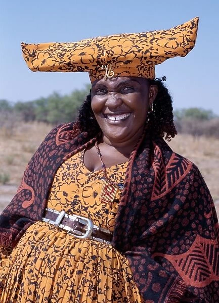 A smartly dressed Herero woman has a beaded AIDS badge