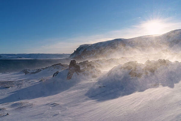 Snow blizzard over rocks covered with ice in the arctic landscape, Sandfjorden, Berlevag, Varanger Peninsula, Finnmark, Norway